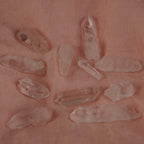 Mehrere lemurianische Quarz Spitzen auf rosa Stoff locker verteilt