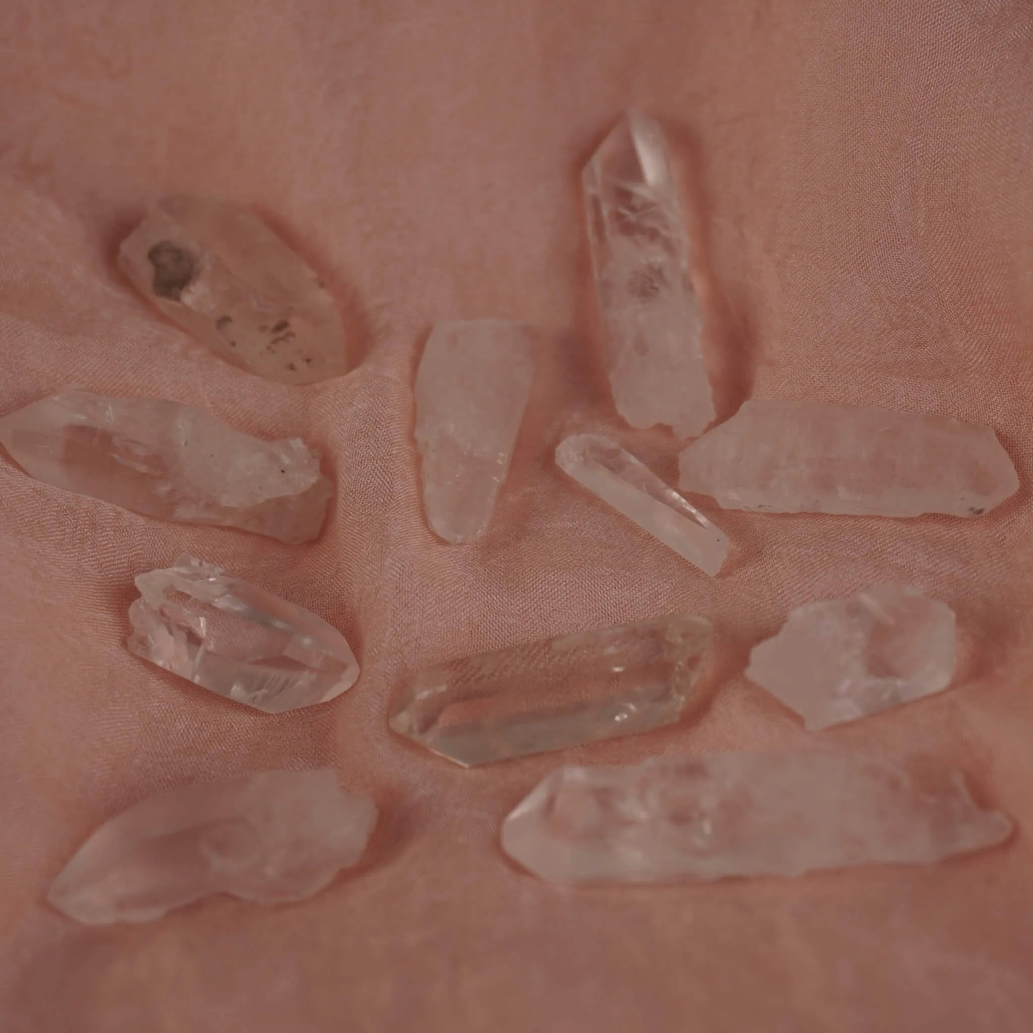 Mehrere lemurianische Quarz Spitzen auf rosa Stoff locker verteilt