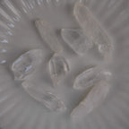 Mehrere lemurianische Quarz Spitzen auf weißem Teller von oben fotografiert