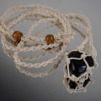 Makramee Halskette mit Edelsteinhalter auf spiegelnder Oberfläche