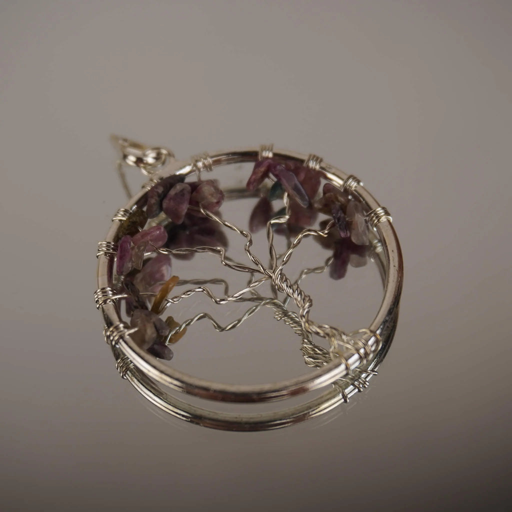 Lebensbaum Kettenanhänger mit mehrfarbigem Turmalin auf spiegelnder Oberfläche