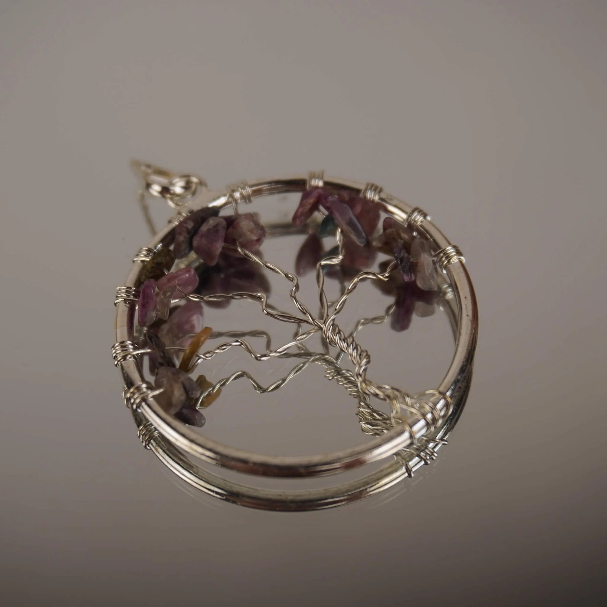 Lebensbaum Kettenanhänger mit mehrfarbigem Turmalin auf spiegelnder Oberfläche