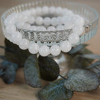 Mondstein Kugelarmband auf elegantem Glasdisplay mit Pflanzen-Dekoration