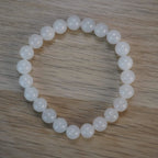 Mondstein Kugelarmband auf Holzoberfläche