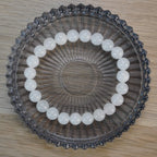 Mondstein Kugelarmband in runder Glasschale auf Holztisch