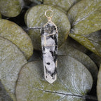 Mondstein Spitze Kettenanhänger dekoriert auf grünen Eukalyptusblättern