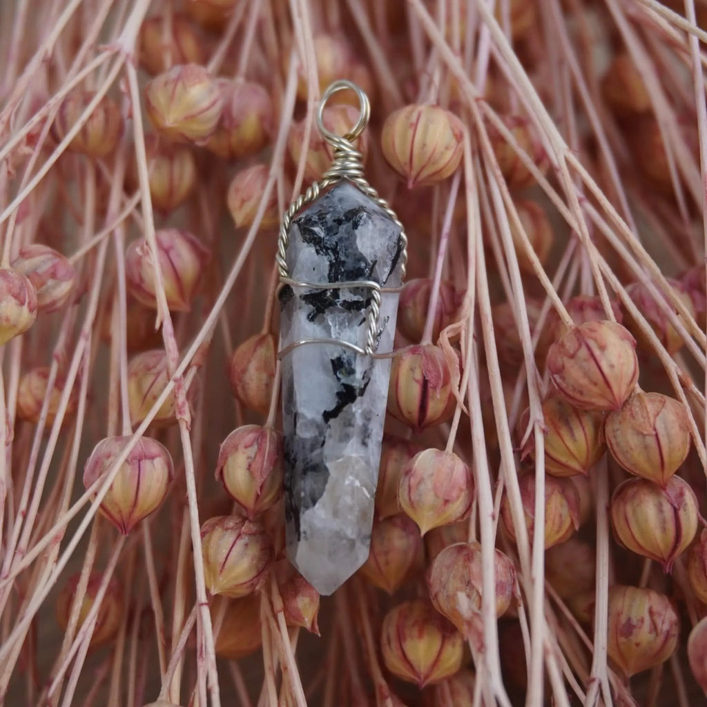 Mondstein Spitze Kettenanhänger mit Silberdraht vor rosa Trockenblumen