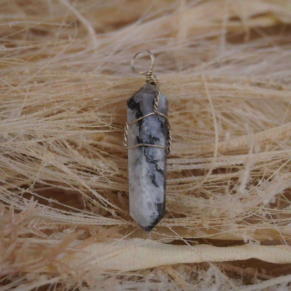 Mondstein Spitze Kettenanhänger mit Silberdraht auf hellen Naturfasern