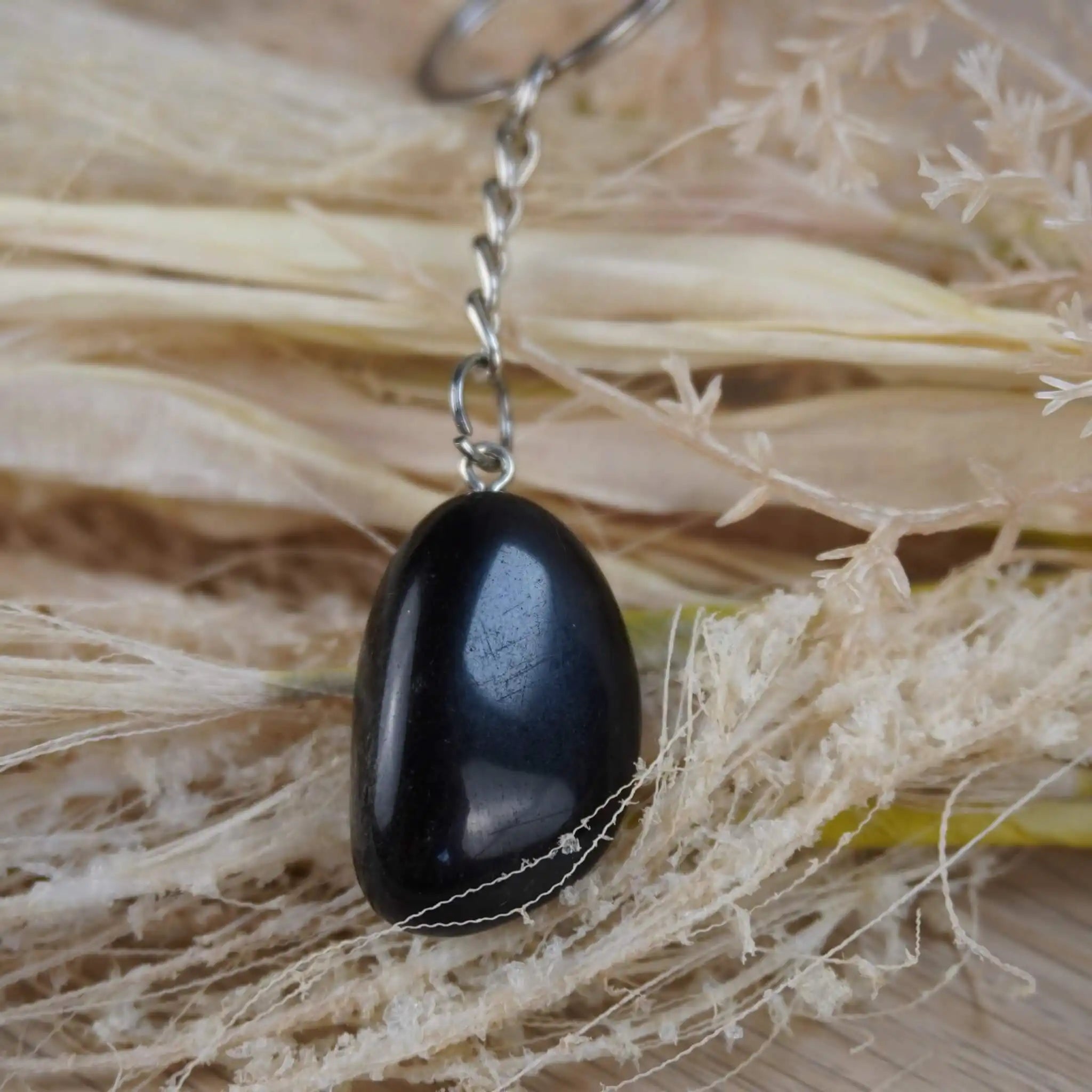 Obsidian Trommelstein Schlüsselanhänger auf Naturfaserdekoration