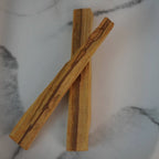 Zwei Palo Santo Hölzer auf hellem Marmorhintergrund