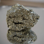 Pyrit Rohstein mit Goldglanz, spiegelnd auf glänzender Oberfläche