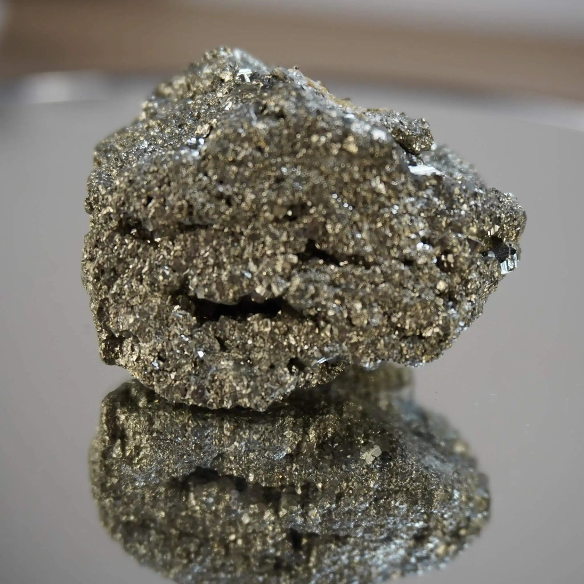 Pyrit Rohstein mit Goldglanz, spiegelnd auf glänzender Oberfläche
