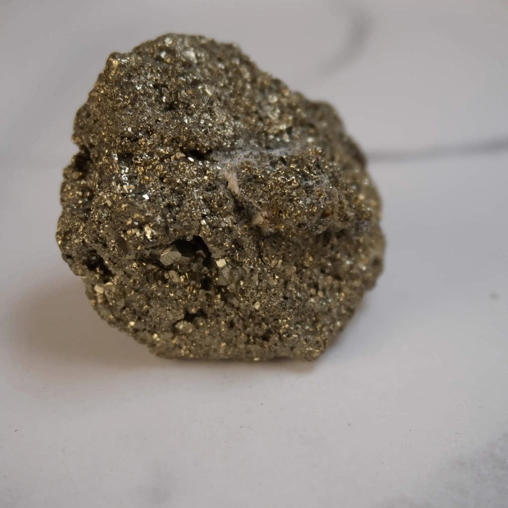 Glitzernder Pyrit Rohstein in Nahaufnahme vor hellem Hintergrund