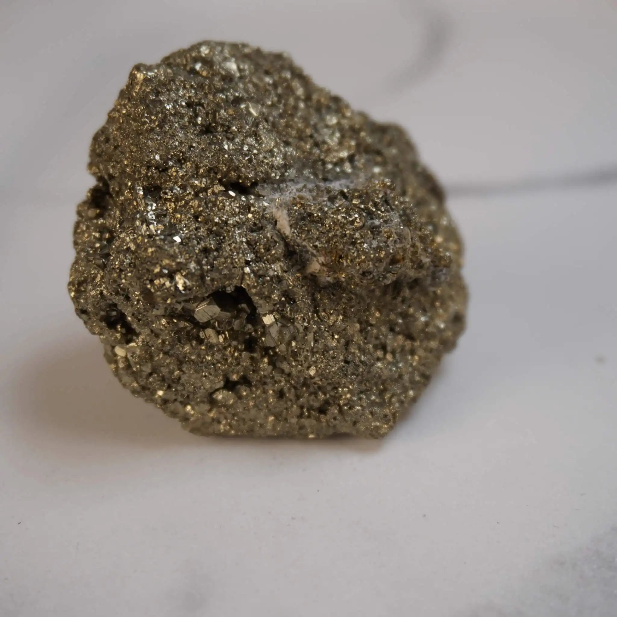 Glitzernder Pyrit Rohstein in Nahaufnahme vor hellem Hintergrund