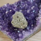Goldschimmernder Pyrit Rohstein auf violettem Amethyst Kristall