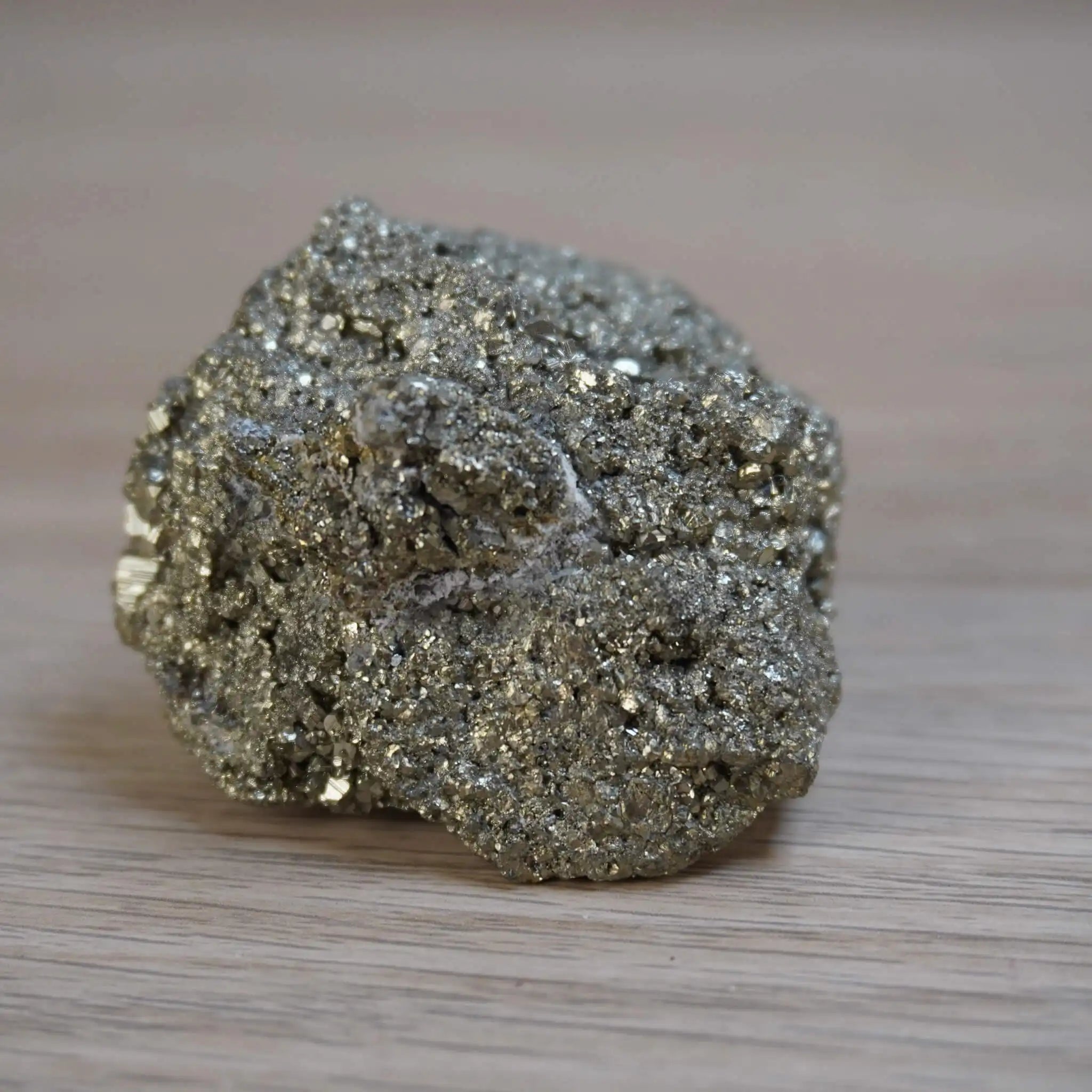 Pyrit Rohstein mit glänzender Oberfläche auf Holz
