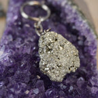 Pyrit Schlüsselanhänger präsentiert auf violetter Amethyst-Druse