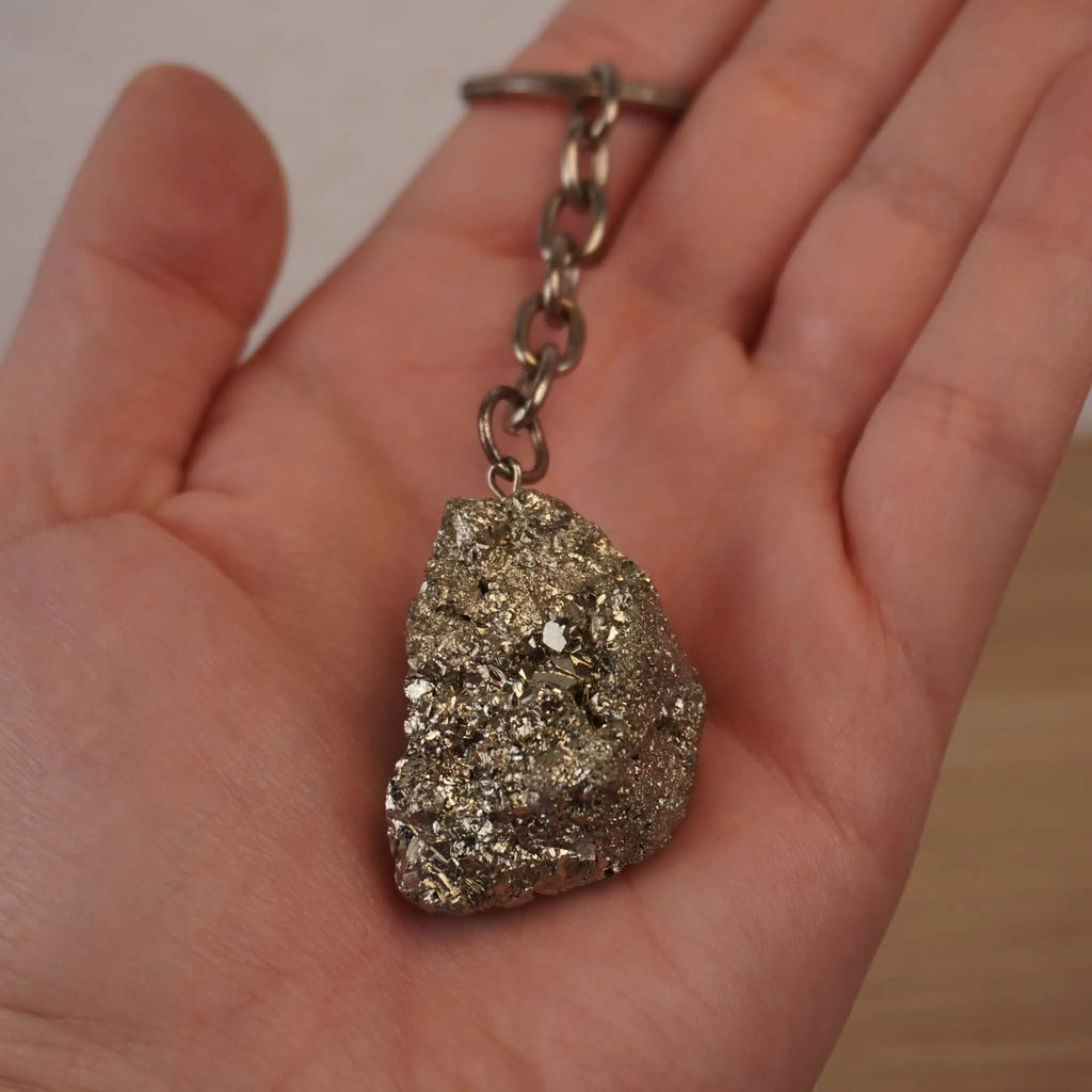 Pyrit Schlüsselanhänger in einer geöffneten Hand gehalten