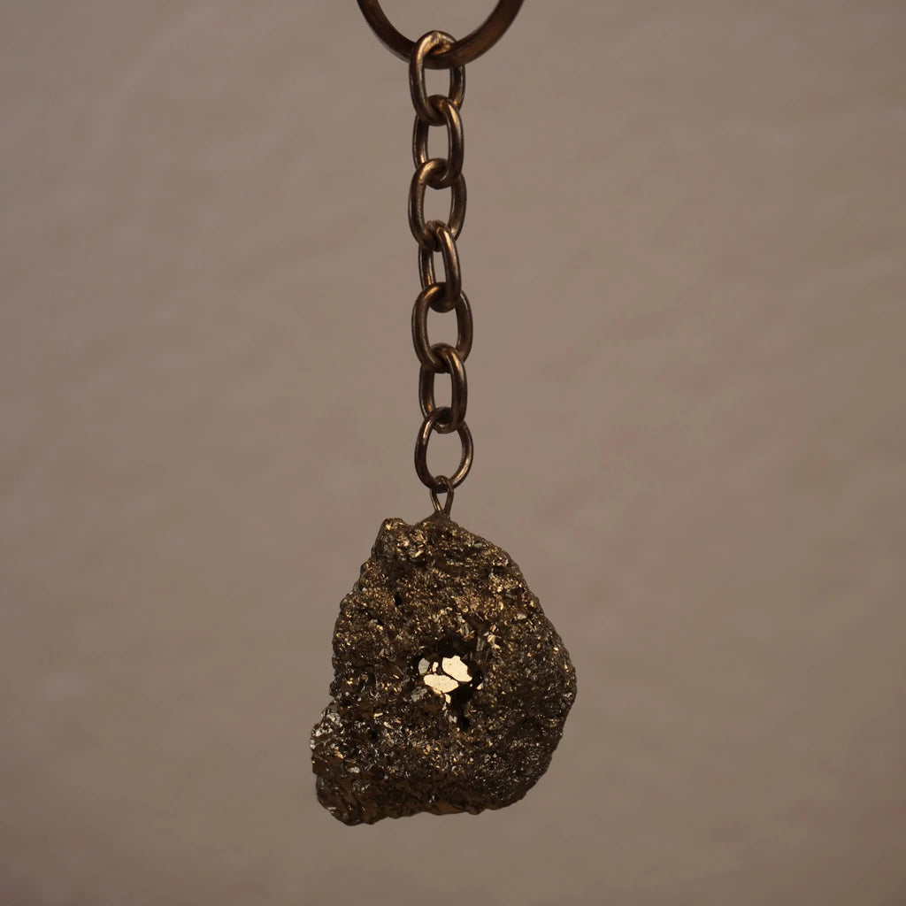Pyrit Schlüsselanhänger frei hängend vor neutralem Hintergrund