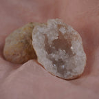 Funkelnde Quarz Geode mit Kristallhöhle auf rosafarbenem Stoff