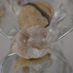 Aufgebrochene Quarz Geode mit innen liegenden Kristallen in transparenter Glasschale