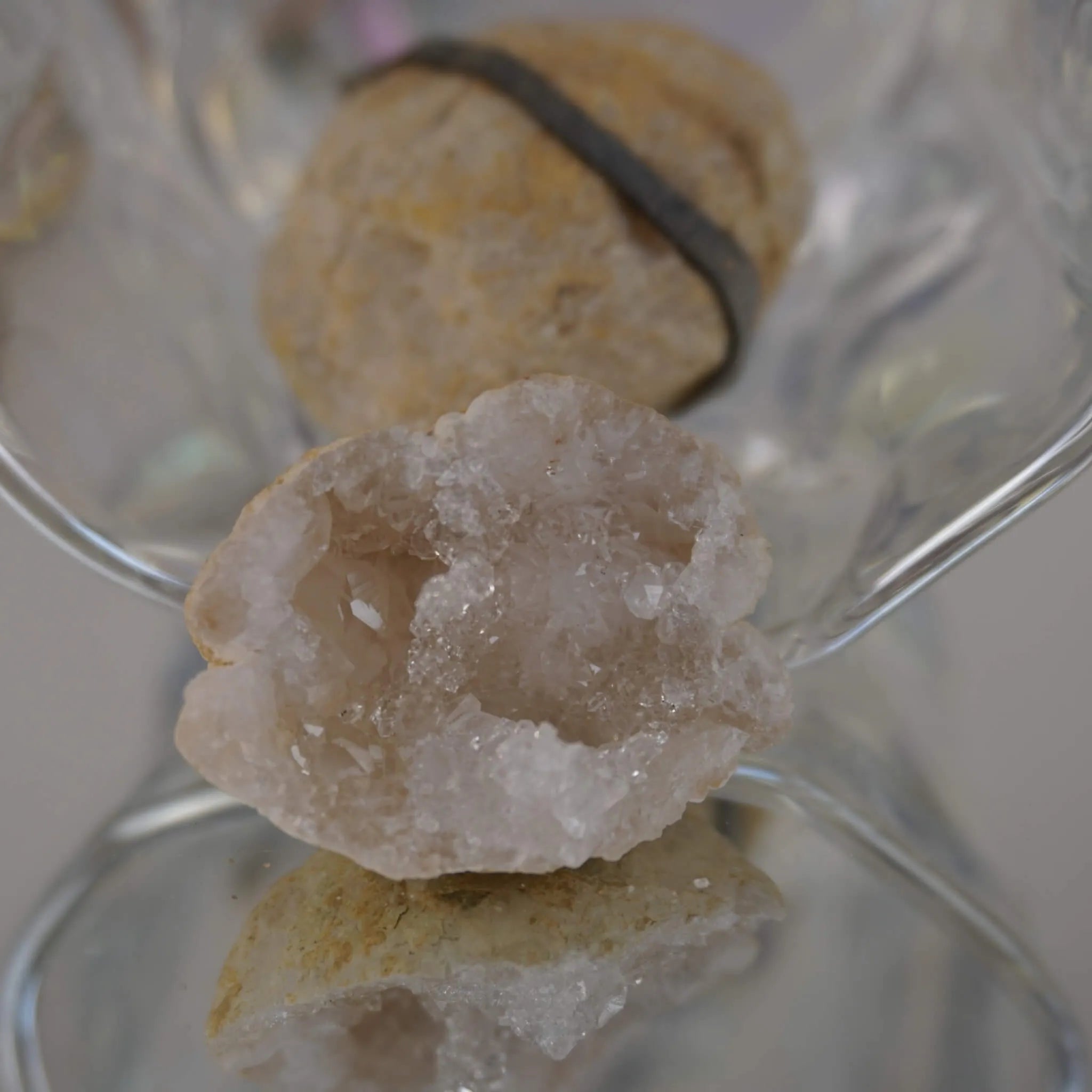 Aufgebrochene Quarz Geode mit innen liegenden Kristallen in transparenter Glasschale