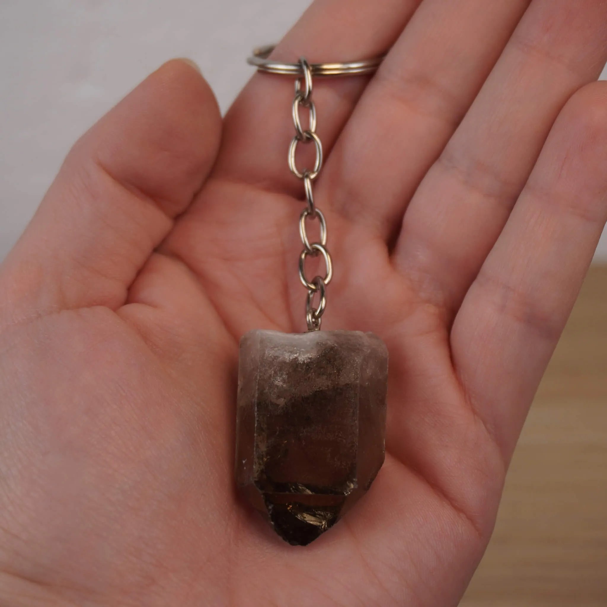 Rauchquarz Spitze Schlüsselanhänger gehalten in einer geöffneten Hand