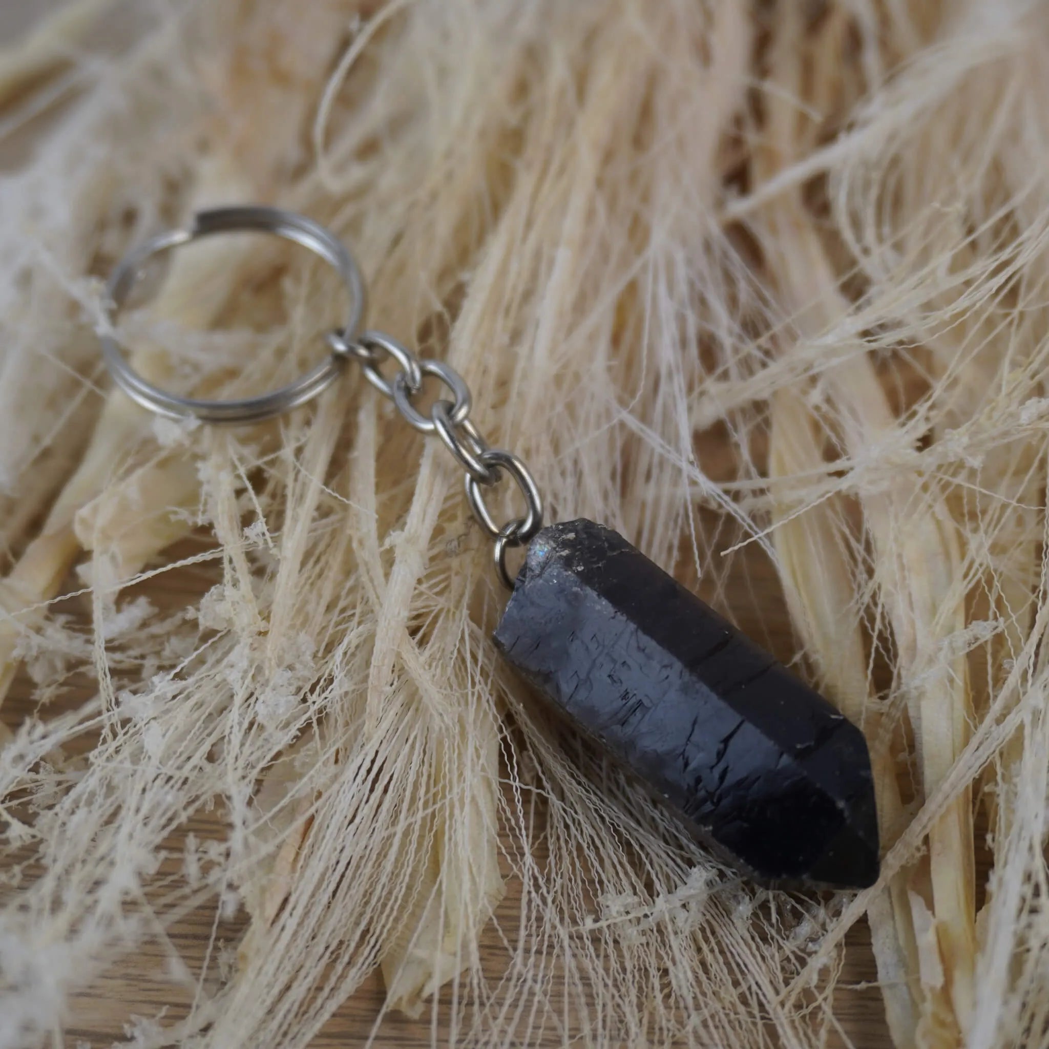 Rauchquarz Spitze Schlüsselanhänger dekoriert auf hellen Naturfasern