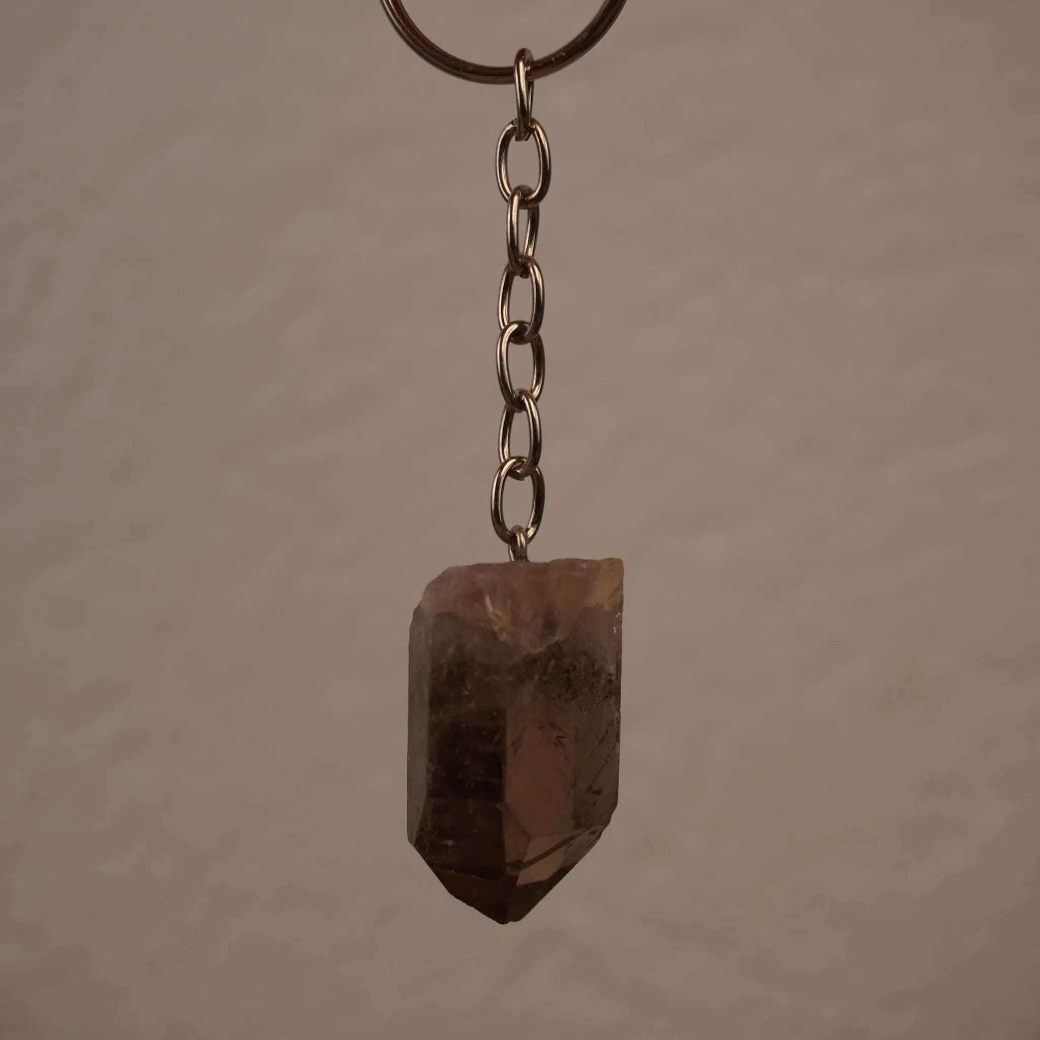 Rauchquarz Spitze Schlüsselanhänger frei hängend vor neutralem Hintergrund