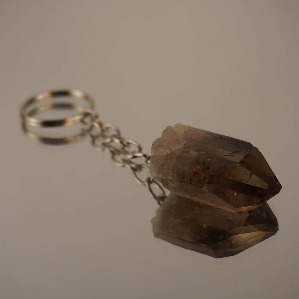 Rauchquarz Spitze Schlüsselanhänger auf spiegelnder Fläche mit Reflexion