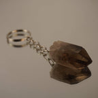 Rauchquarz Spitze Schlüsselanhänger auf spiegelnder Fläche mit Reflexion