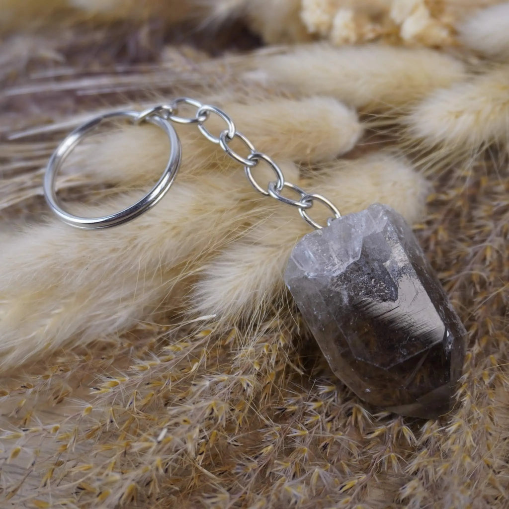 Rauchquarz Spitze Schlüsselanhänger auf beigen flauschigen Trockenpflanzen
