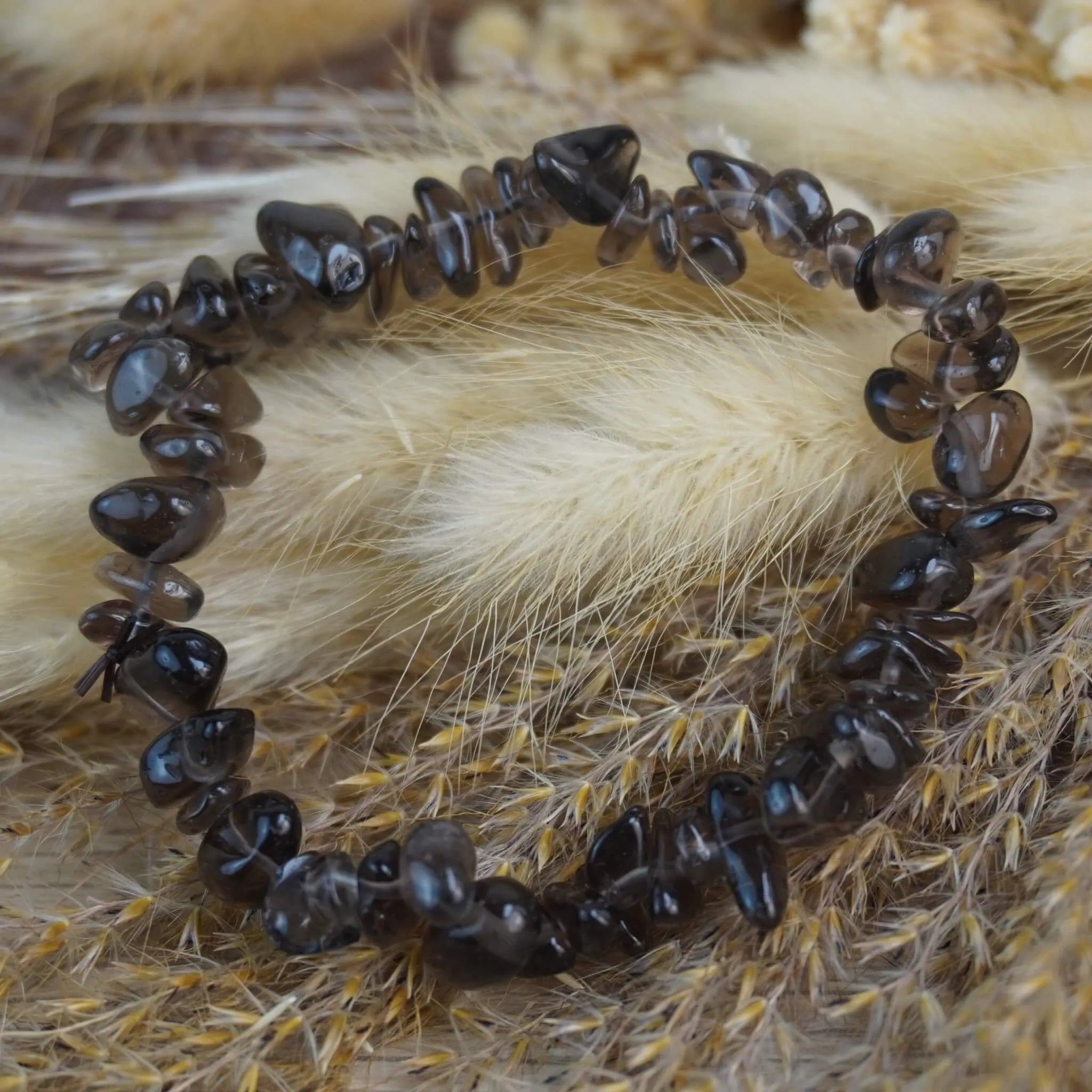 Rauchquarz‑Splitterarmband auf hellen Trockenblumen