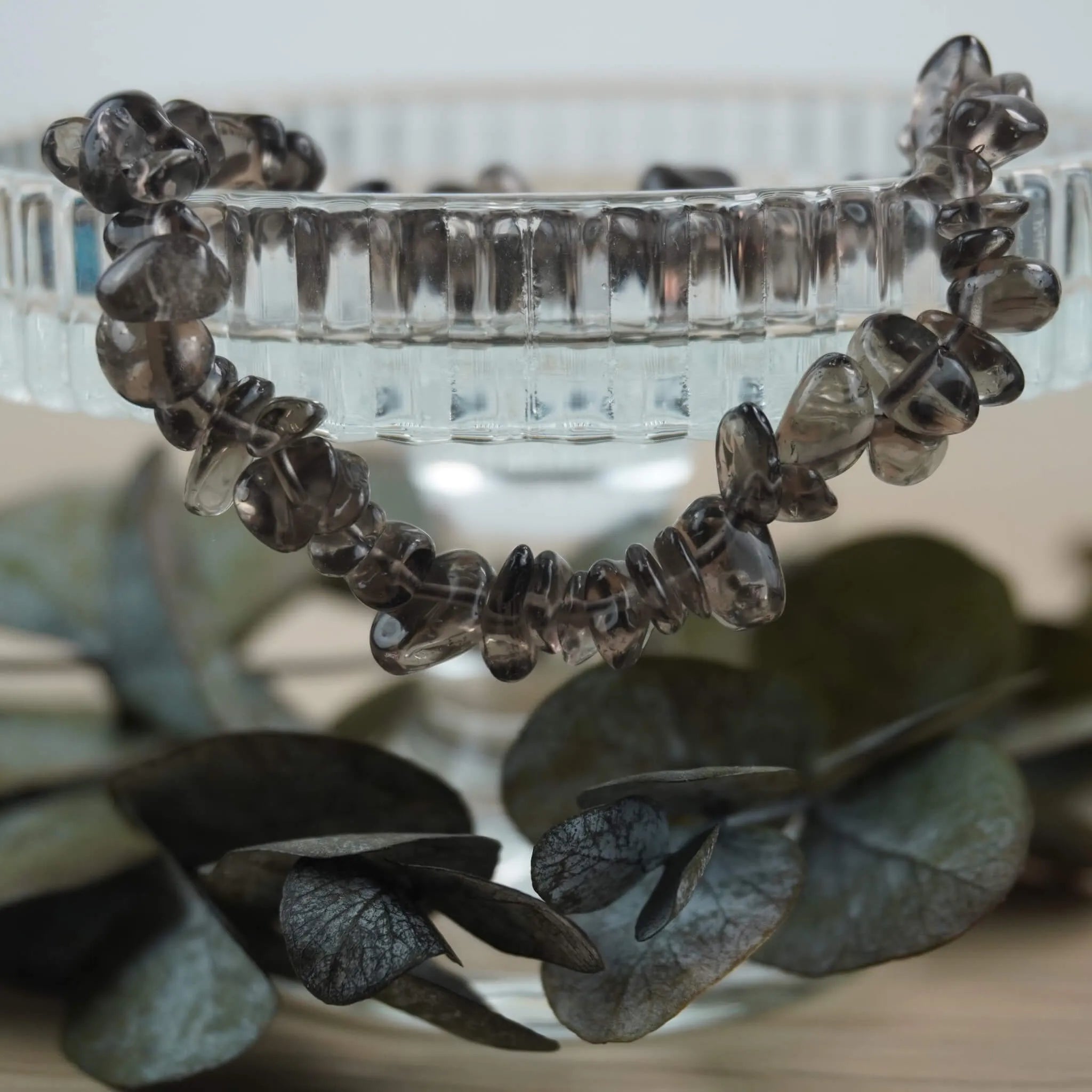 Rauchquarz‑Splitterarmband auf Glas‑Schale mit Eukalyptus