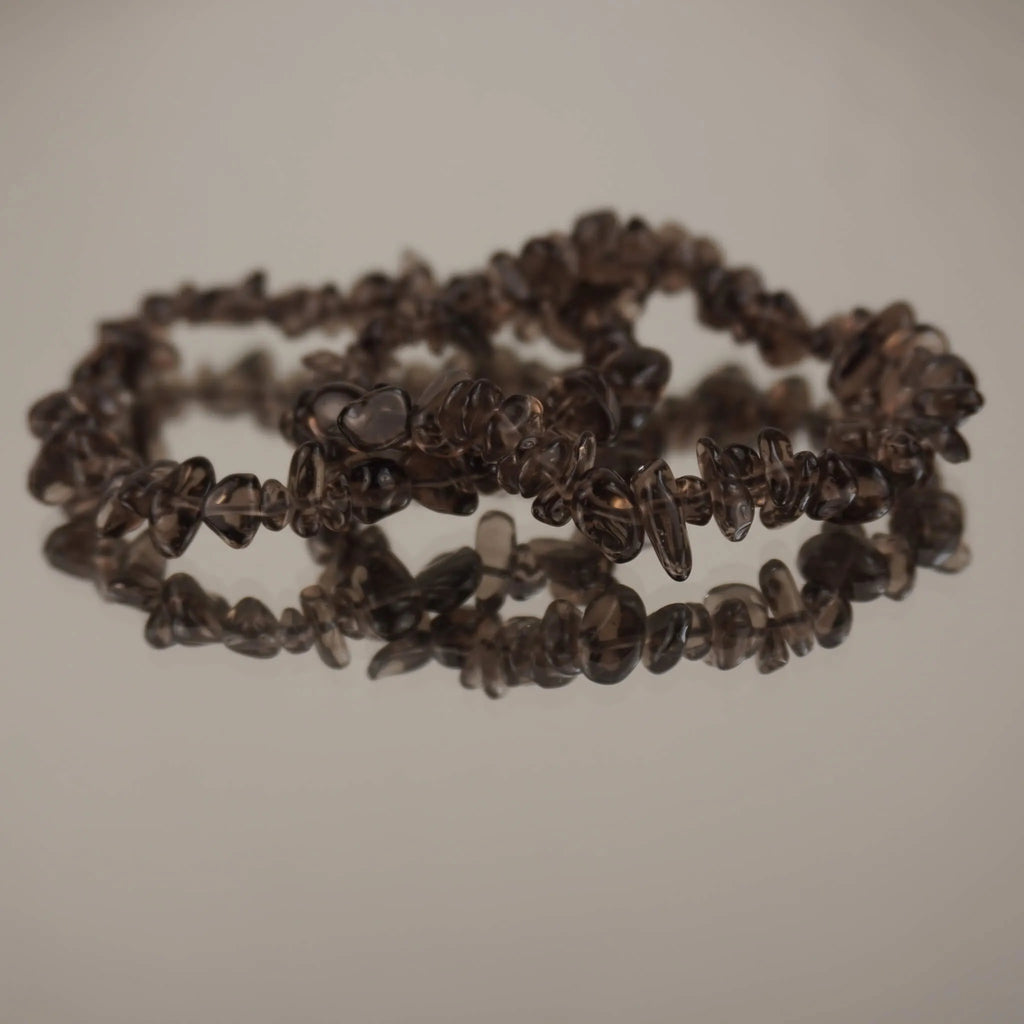 Rauchquarz‑Splitterarmband auf spiegelnder, heller Fläche