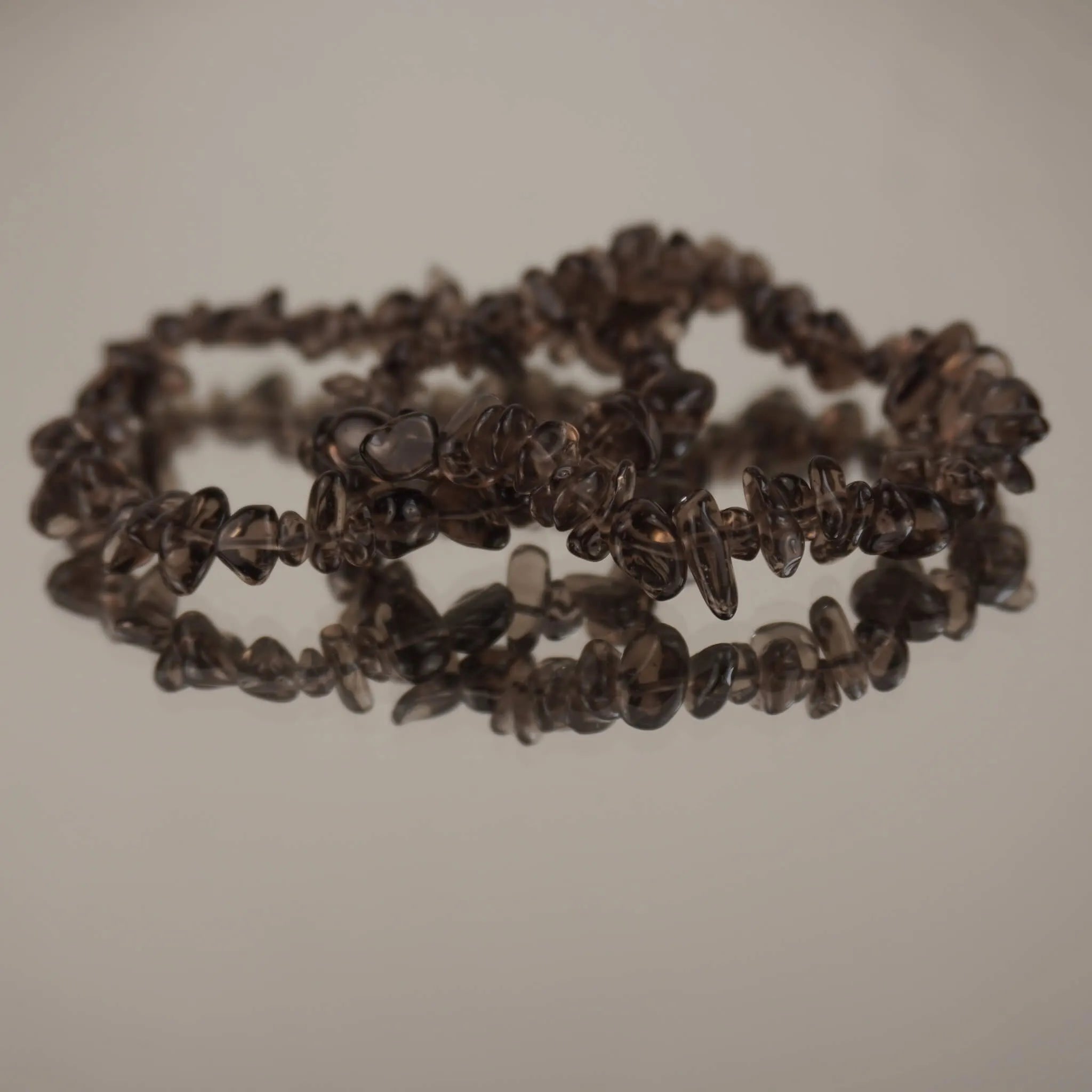 Rauchquarz‑Splitterarmband auf spiegelnder, heller Fläche