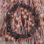 Rauchquarz‑Splitterarmband dekoriert auf rosafarbenen Trockenblumen