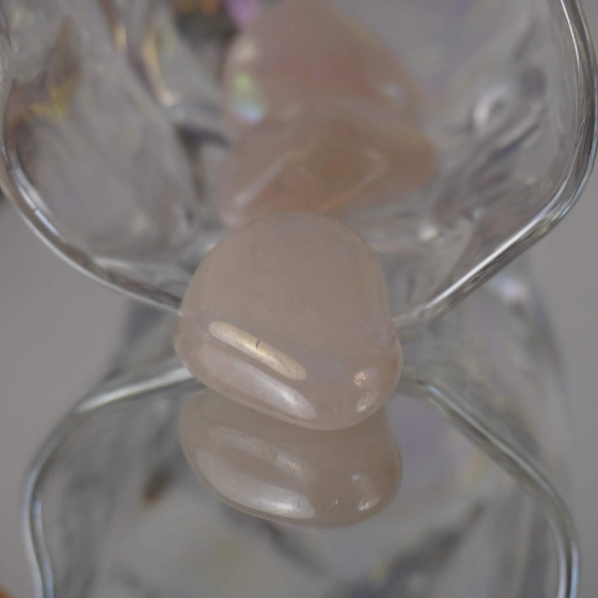 Rosa Angel Aura Trommelstein mit Spiegelung am Rand einer transparenten Glasschale