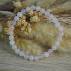 Rosenquarz Kugelarmband vor Trockenblumen Hintergrund