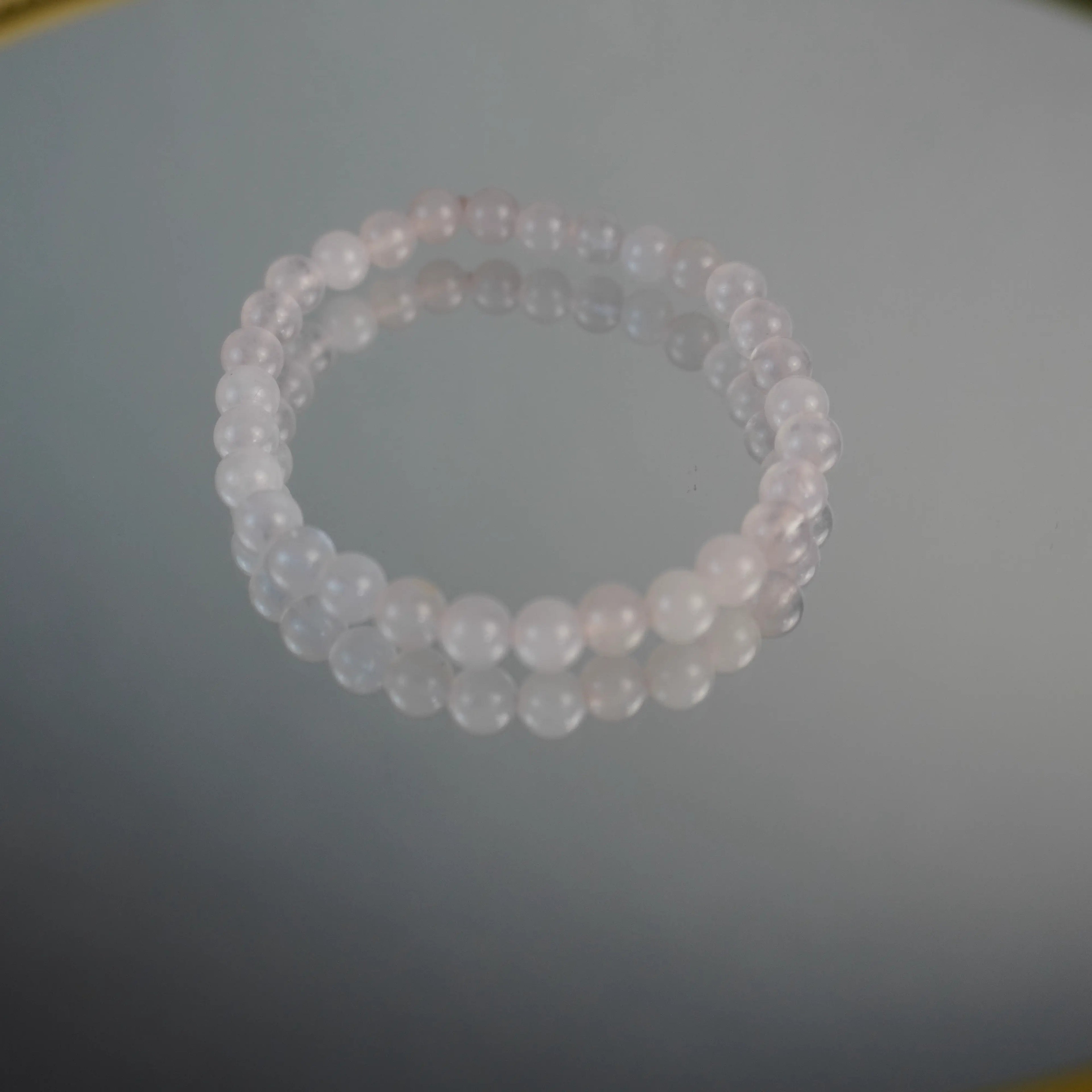 Zartrosa Rosenquarz Armband aus Kugelperlen auf Spiegel