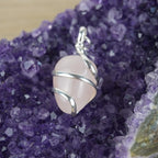 Rosenquarz Kettenanhänger mit Silberfassung präsentiert auf violetter Amethyst-Druse