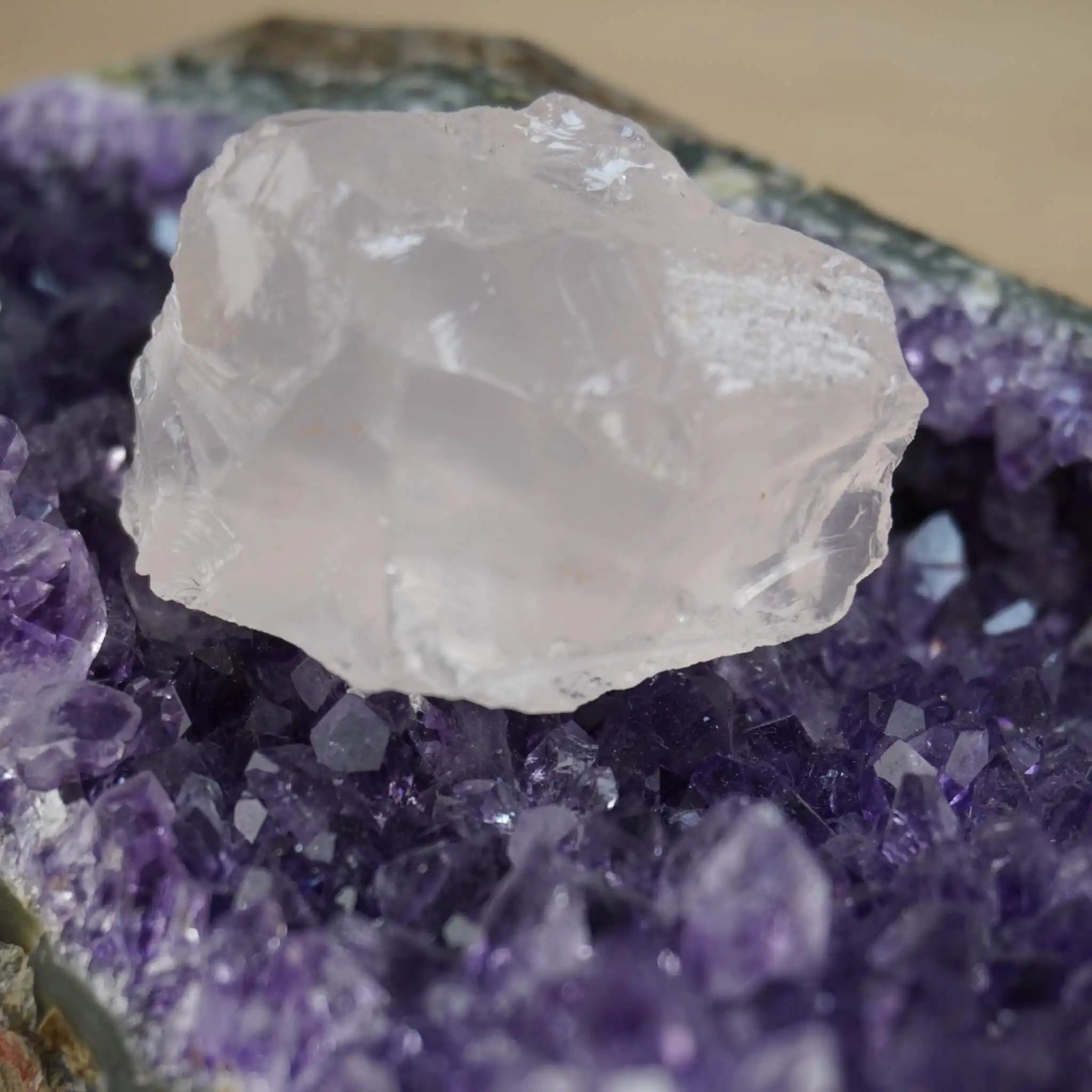 Rosenquarz Rohstein dekorativ auf einer Amethystdruse