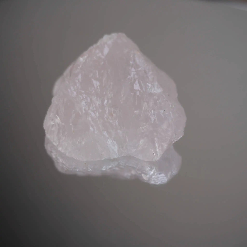 Rosenquarz Rohstein auf spiegelnder Oberfläche mit schöner Struktur