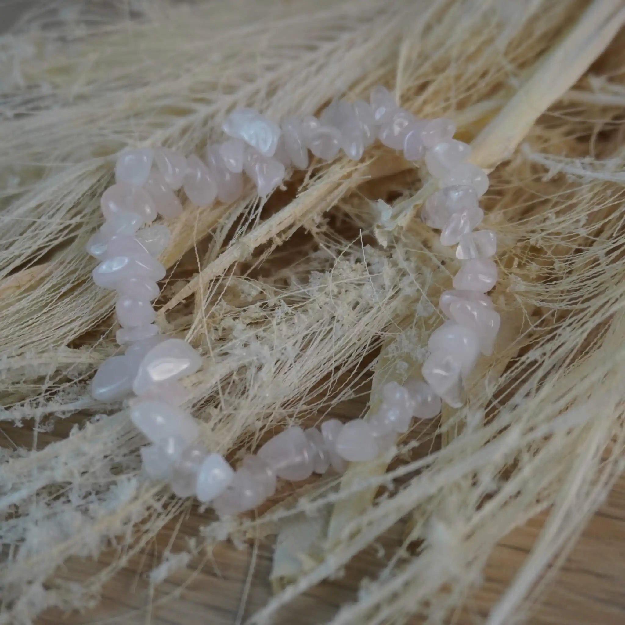 Rosenquarz Splitterarmband auf Trockenblumen und Gräsern