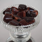 Mehrere rote Tigerauge Trommelsteine mit satten Rottönen in einem Glaskelch