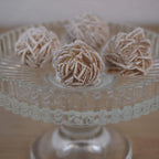 Mehrere Sandrosen Mineralien auf einem gläsernen Ständer arrangiert