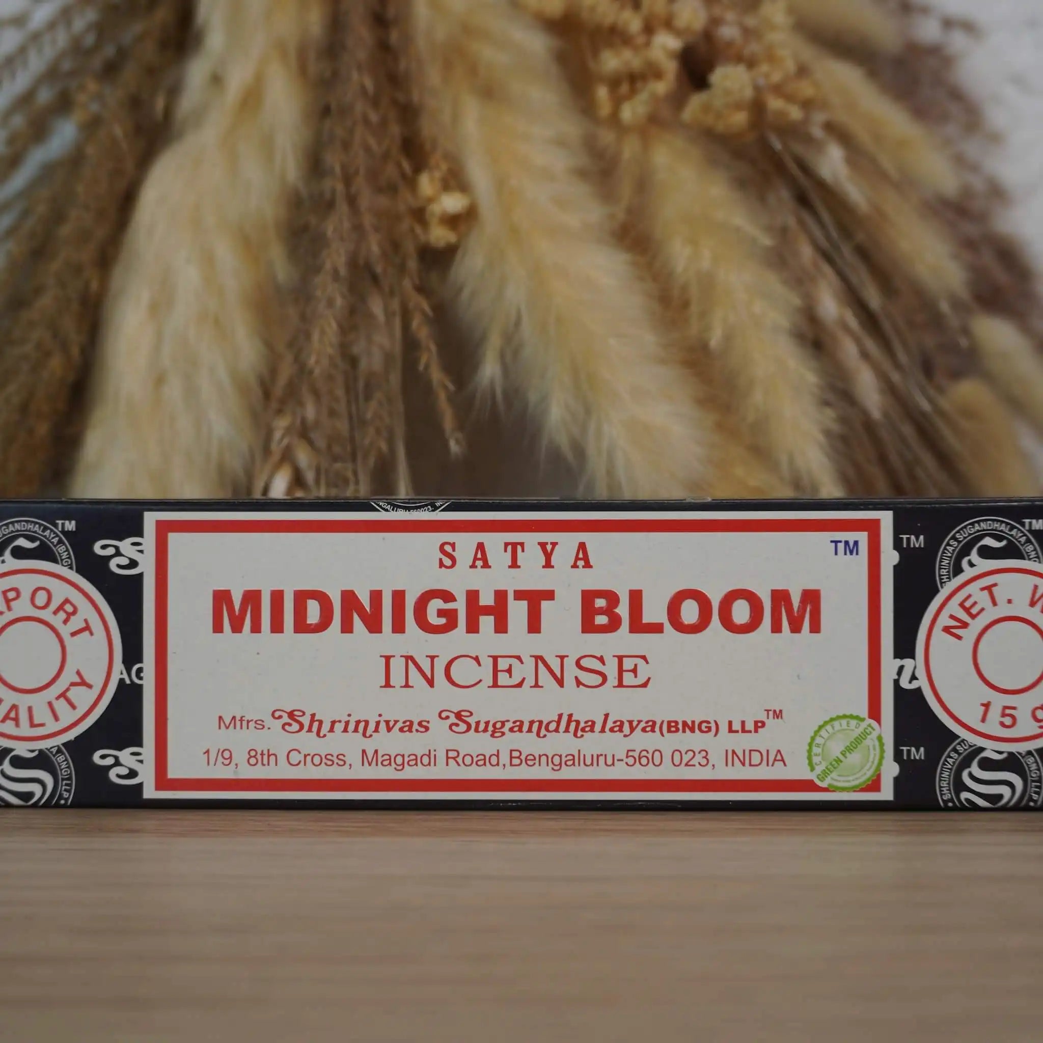 Satya Midnight Bloom Räucherstäbchen Packung vor getrockneten Gräsern