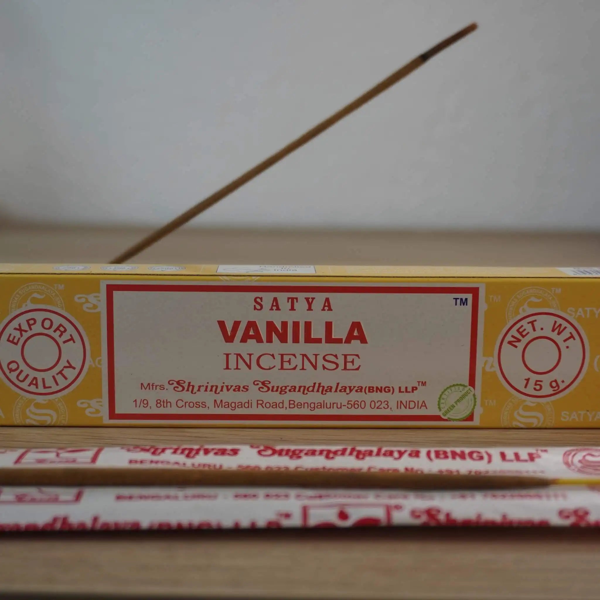 Satya Vanilla Räucherstäbchen Packung mit angezündetem Räucherstäbchen im Vordergrund