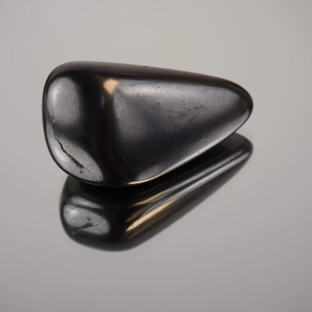 Schungit Trommelstein mit glänzender Oberfläche und klarer Spiegelung