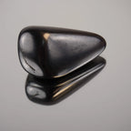 Schungit Trommelstein mit glänzender Oberfläche und klarer Spiegelung